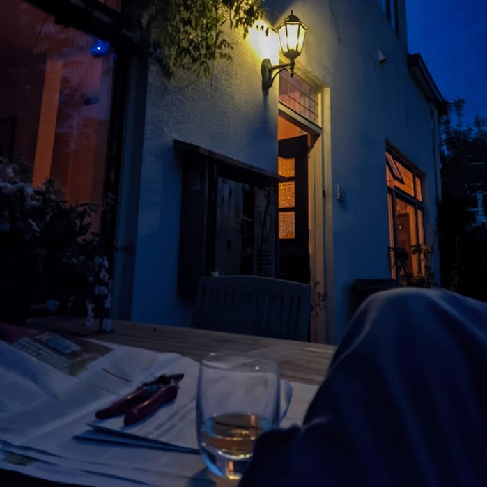 Gezellig verlichte open deur van Logies op Dreef in schemering, gastvrijheid uitstralend.